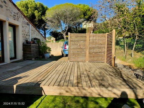 Création d'une terrasse en bois avec brise vue .